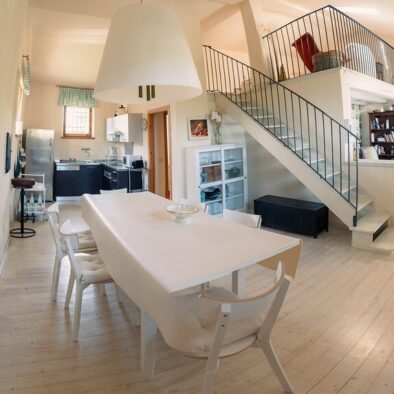Vista open space del Loft Verdemare a Fano con cucina attrezzata, zona pranzo, soggiorno con camino e soppalco – ideale per vacanze in famiglia nelle Marche.