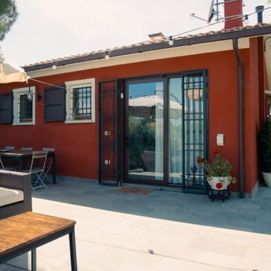 Loft Verdemare a Fano con ingresso indipendente, patio arredato e area relax all’aperto – affitto turistico ideale vicino al mare. Casa vacanze moderna con pareti rosso scuro, infissi bianchi, porta scorrevole in vetro, grate di sicurezza e arredamento da giardino. Alloggio perfetto per soggiorni a Fano, nelle Marche, in zona tranquilla e verde.
